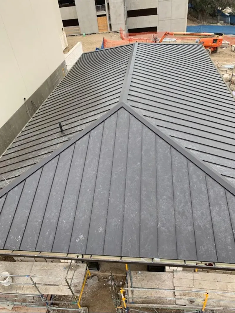 Commercial metal roof construction with crane equipment in Moultonborough